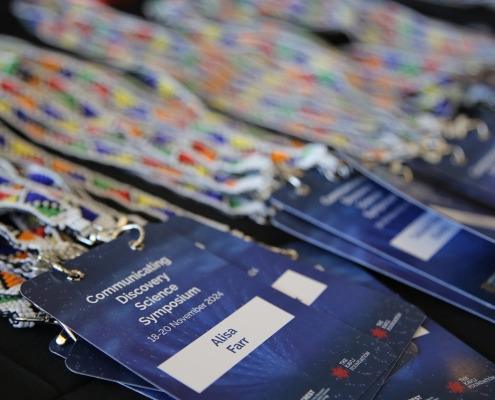 Delegates are ready for an inspiring start at the Communicating Discovery Science Symposium, with each nametag a symbol of their valuable contribution to the conversation on science communication.