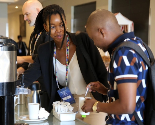 Delegates taking a moment to enjoy a coffee break, reconnecting and sharing insights during the session interlude.